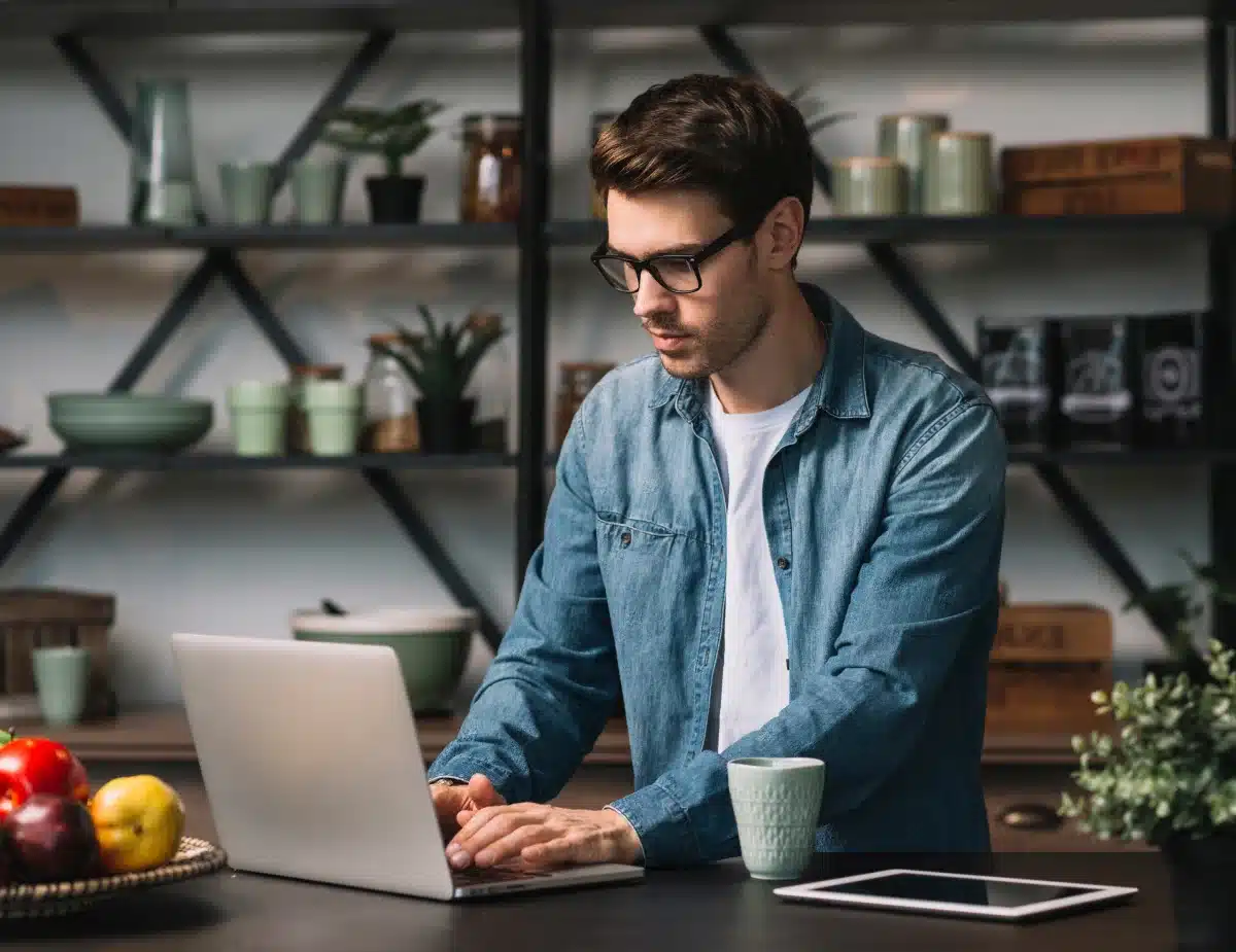 a man sitting at a table using a laptop