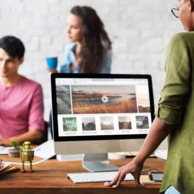 a woman standing at a desk with a computer